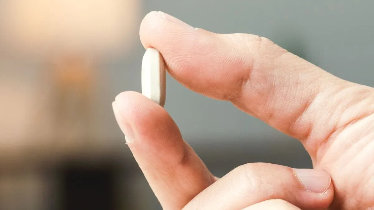 close up of hand holding medicine pill