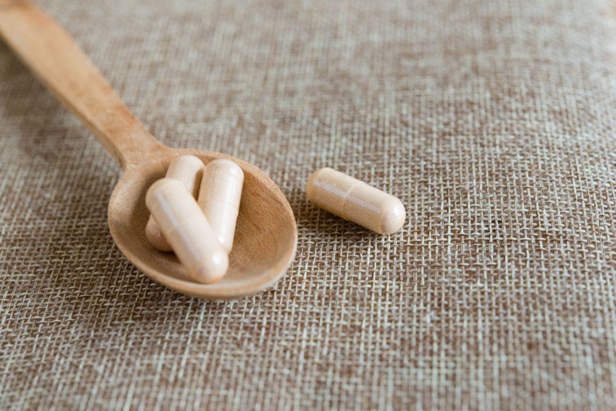 healthy herbal supplements on a wooden spoon